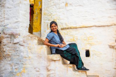 Geleneksel beyaz evin önündeki kadın, Hindistan.