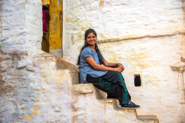 Geleneksel beyaz evin önündeki kadın, Hindistan.