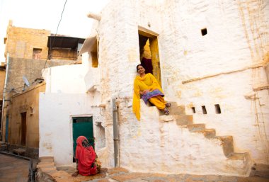 Geleneksel beyaz evin önündeki kadın, Hindistan.