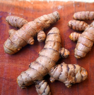 Arkaplanda taze zerdeçal kökleri