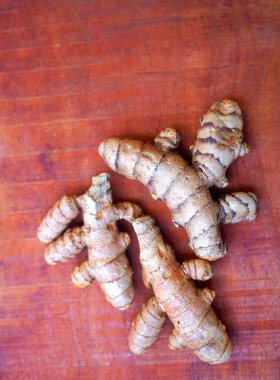 Arkaplanda taze zerdeçal kökleri