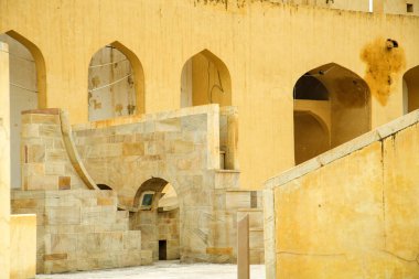 Antik astronomik gözlem evi Jantar Mantar, Jaipur, Rajasthan, Hindistan 'daki klasik sarı duvarlardaki soyut kalıplar.