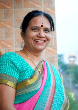 Gülümseyen olgun Hintli kadın portresi.