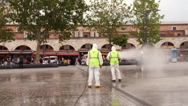 Istanbul, TÜRKEI - 20. Juni 2020: Mitarbeiter des Gesundheitswesens sprühen Desinfektionsmittel in der Altstadt in Zeitlupe — Stockvideo