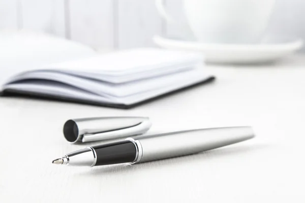 Silver roller pen with notebook Royalty Free Stock Photos