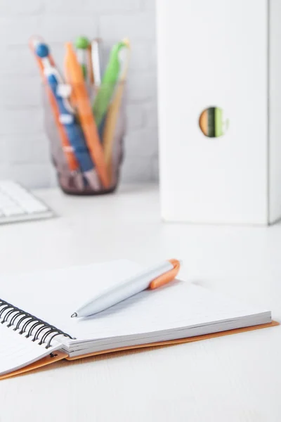 Orange ball pen with notebook Stock Photo