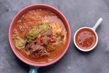 El bir bardak domuz suki tutuyordu..