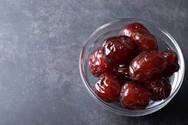 Jujube siyah bir arka planda bir şişede şekerli. Bedava alan.