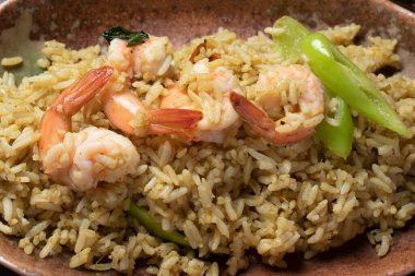 Ahşap zeminde yeşil körili pilav.