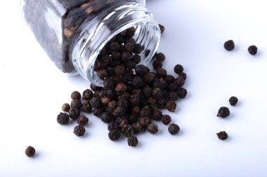 Siyah arka planda cam kavanozda biber.