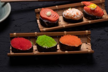 Siyah arka planda bambuyla suşi.