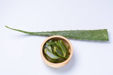 Aloe Vera, beyaz arka planda tahta bardakta.