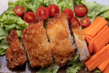 Close up. Fried chicken salad with vegetables, tomatoes, carrots, green oak.
