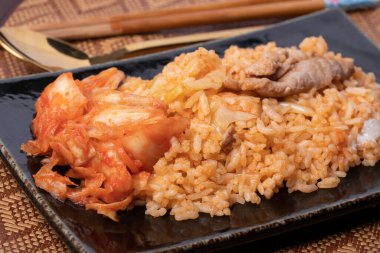 Siyah tabakta kimchi pilavı, Kore yemeği tarzı yakın plan.