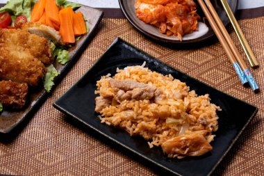 Kimchi Fried Rice in Black Plate and Korean Style Fried Chicken Salad