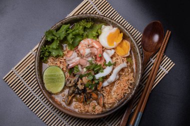 Deniz mahsulü erişteler. Tom, karides, kalamar, kahverengi seramik kasede midye.