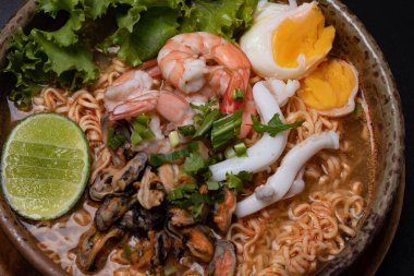 Deniz mahsulü erişteler. Tom, karides, kalamar, kahverengi seramik kasede midye.