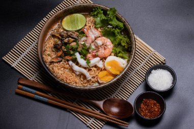 Deniz mahsulü erişteler. Tom, karides, kalamar, kahverengi seramik kasede midye.