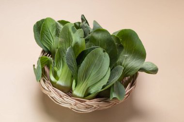 Bok choy (Pak choi) kahverengi arka planda bambu sepetinde iki taze lahana..