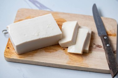 Beyaz kare tofu küpleri Tahta kesme tahtasında ve bir bıçakta