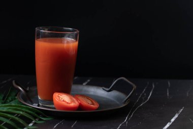 Açık bardakta domates suyu ve koyu tonda kırmızı kokteyl..