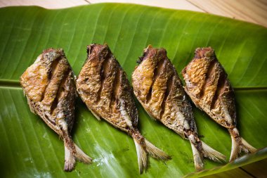 Muz yaprağı arka planında kızarmış uskumru.