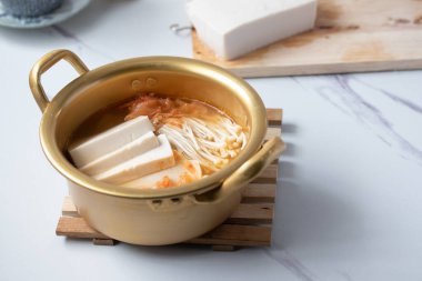 Beyaz arka planda bir kasede tofu ile iğne mantarlı kimchi çorbası, Kore yemeği (Kimchi Jjigae)
