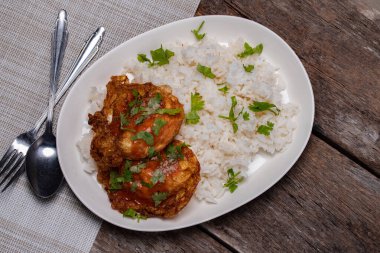 Tahta zeminde beyaz bir tabakta kızarmış yumurta ve pilav..