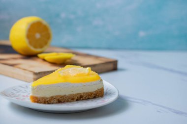 Gri mermer arka planda üçgen limonlu cheesecake