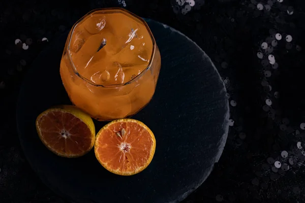 黒の背景に透明なガラスの中に新鮮な絞りオレンジジュース — ストック写真