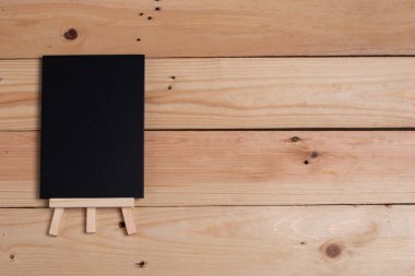 Harf eklemek için tahta zemin üzerinde boş siyah kağıt.