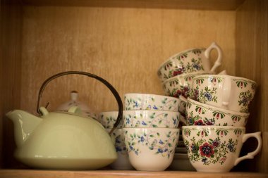 Seramik çanak çömlek ve kaseler ev dekorasyonu için bir dolaba yerleştirilmiş..