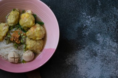 Pork wonton noodle, siyah arka plan masasında beyaz vermicelli.