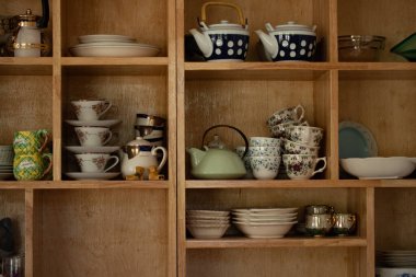 Seramik çanak çömlek ve kaseler ev dekorasyonu için bir dolaba yerleştirilmiş..