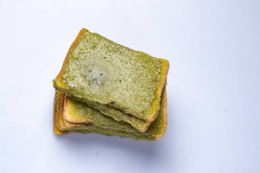 Beyaz arka planda yeşil çay kremalı ince dilimler..