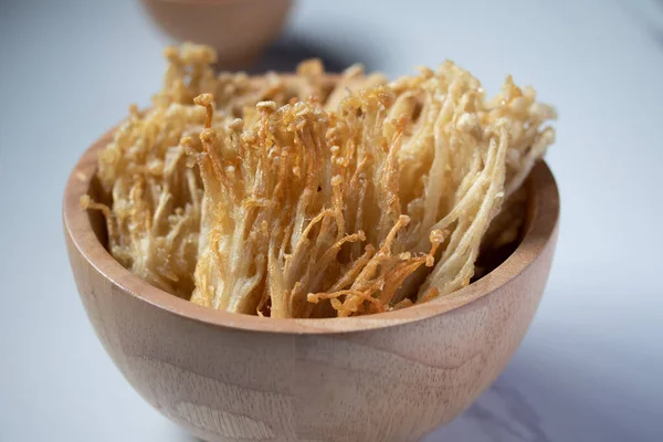 Beyaz tabakta baharat soslu çıtır altın iğneli mantar.