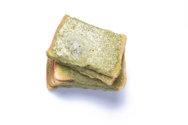 Beyaz arka planda yeşil çay kremalı ince dilimler..