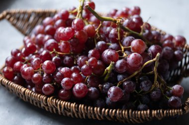 Tahta bir sepetin içindeki mor üzümler..