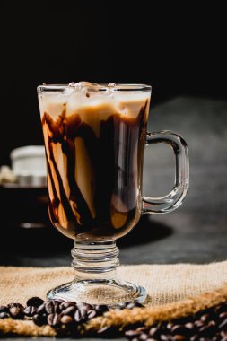 Ahşap masada soğuk taze kahve ve siyah arka plan.