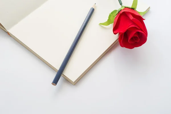 bir defter ve kalem kırmızı gül