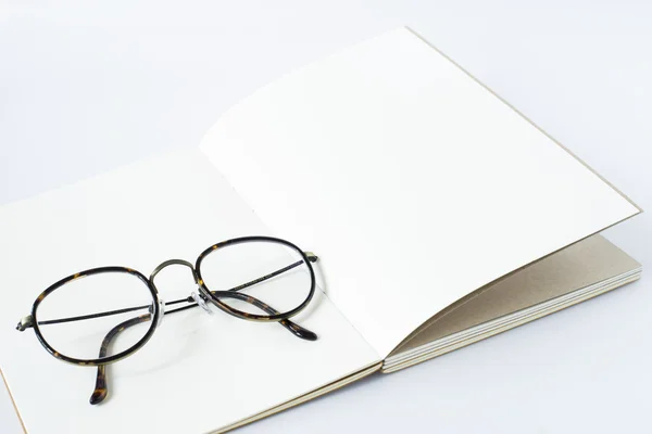 açılan defter, beyaz arka plan beyaz sayfa üzerinde gözlük