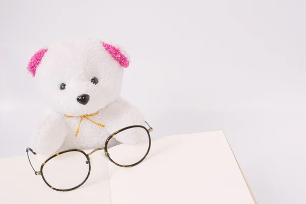 Dolly bear with glasses on notepad, vintage style — Stock Photo, Image