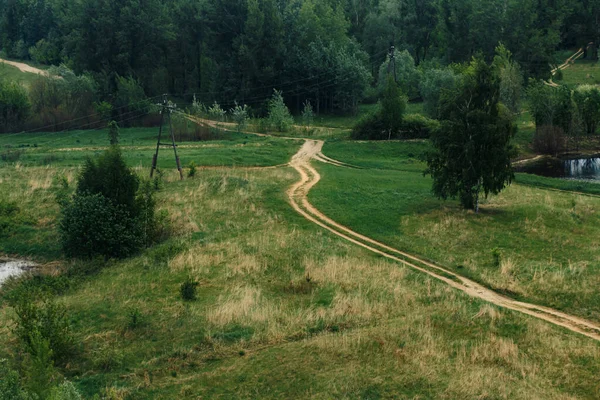 Yeşil tepelerdeki toprak yol