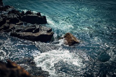 Köpüklü su kayalara sıçrar.