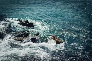 Köpüklü su kayalara sıçrar.