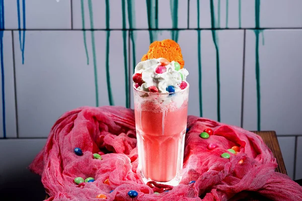 Gri arka planda krem şantili çilekli milkshake.