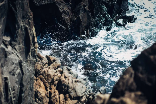 Köpüklü su kayalara sıçrar.