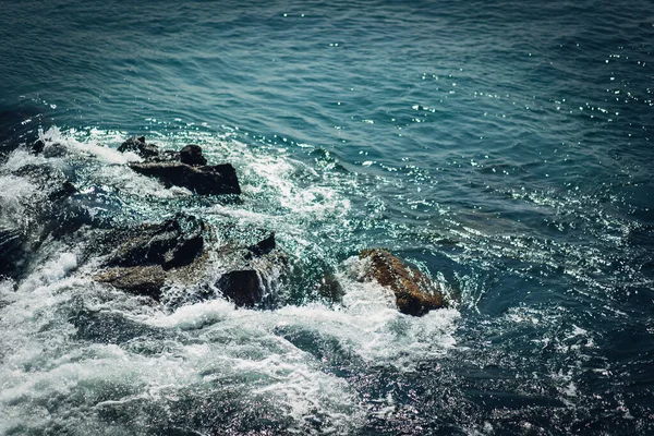 Köpüklü su kayalara sıçrar.