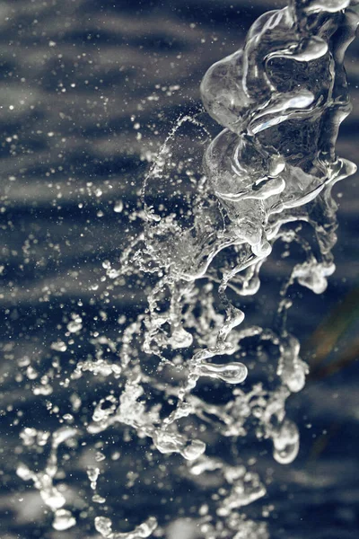 Water Spat Een Blauwe Achtergrond — Stockfoto