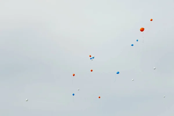 Gri gökyüzü arka planında renkli balonlar